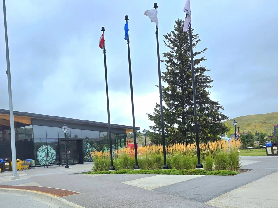 Modern civic plaza with flagpoles in downtown Cochrane, Alberta