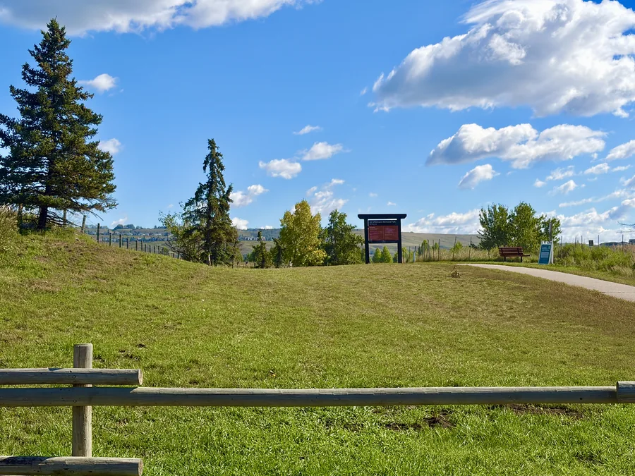 Jim Uffelmann Memorial Park sign and pathway in Greystone, Cochrane, Alberta