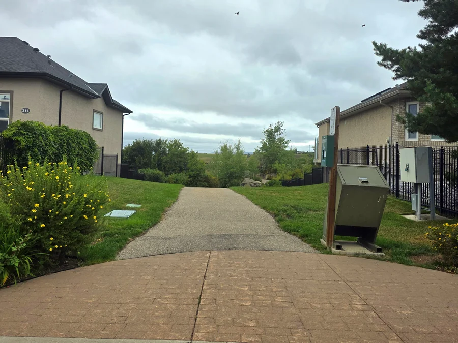 Paved pathway between homes in Sunterra Ridge, Cochrane, Alberta